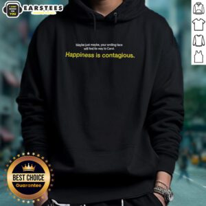 Smiling person wearing 'Happiness Is Contagious' hoodie, radiating joy and positivity in a vibrant outdoor setting.