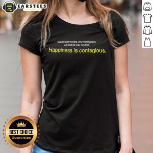Smiling woman wearing 'Happiness is Contagious' tee, radiating joy in a sunny outdoor setting, embodying positivity.