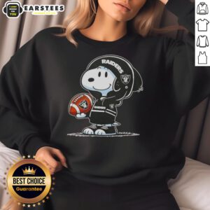 Alt Text: Cute Snoopy in a hoodie featuring Las Vegas Raiders, smiling at fans while wearing a cozy sweatshirt.