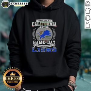 Detroit Lions football hoodie with 'I May Live in California But On Game Day' slogan, perfect for fans and game day attire.