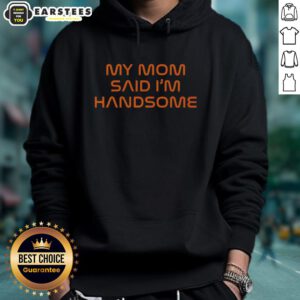 Boy wearing 'Good-My-Mom-Said-Im-Handsome' hoodie, smiling confidently in a bright outdoor setting.