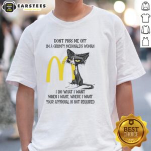 Grumpy cat wearing a McDonald's-themed t-shirt with the phrase 'Don't Piss Me Off, I'm a Grumpy McDonald's Woman.'