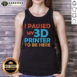Top I Paused My 3D Printer To Be Here tank top displayed on a wooden background, perfect for 3D printing enthusiasts.