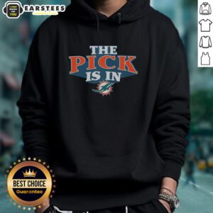 Fan wearing a Good Miami Dolphins pick is in hoodie, showcasing team spirit at a game day event.